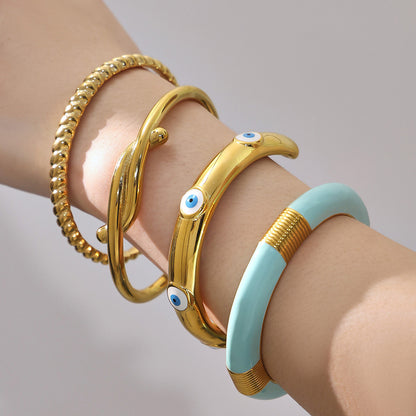 18k gold enamel stainless steel bangle set, layered on model's wrist