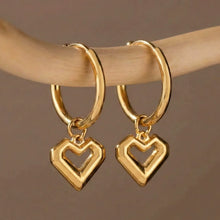 Flat lay of everyday jewelry wholesale featuring 316L stainless steel heart pendant hoop earrings.