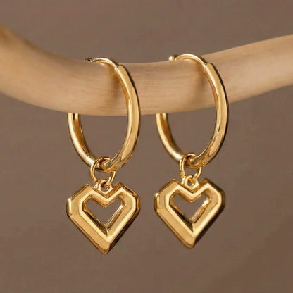 Flat lay of everyday jewelry wholesale featuring 316L stainless steel heart pendant hoop earrings.