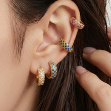 Gold-tone CZ lattice hoops with colorful stones worn in a layered ear stack.