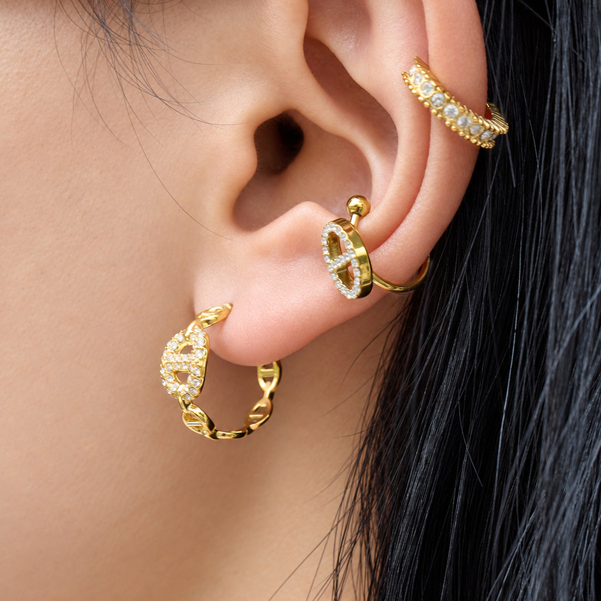 Side view of geometric gold hoop earrings showing pavé zircon detailing and linked chain elements