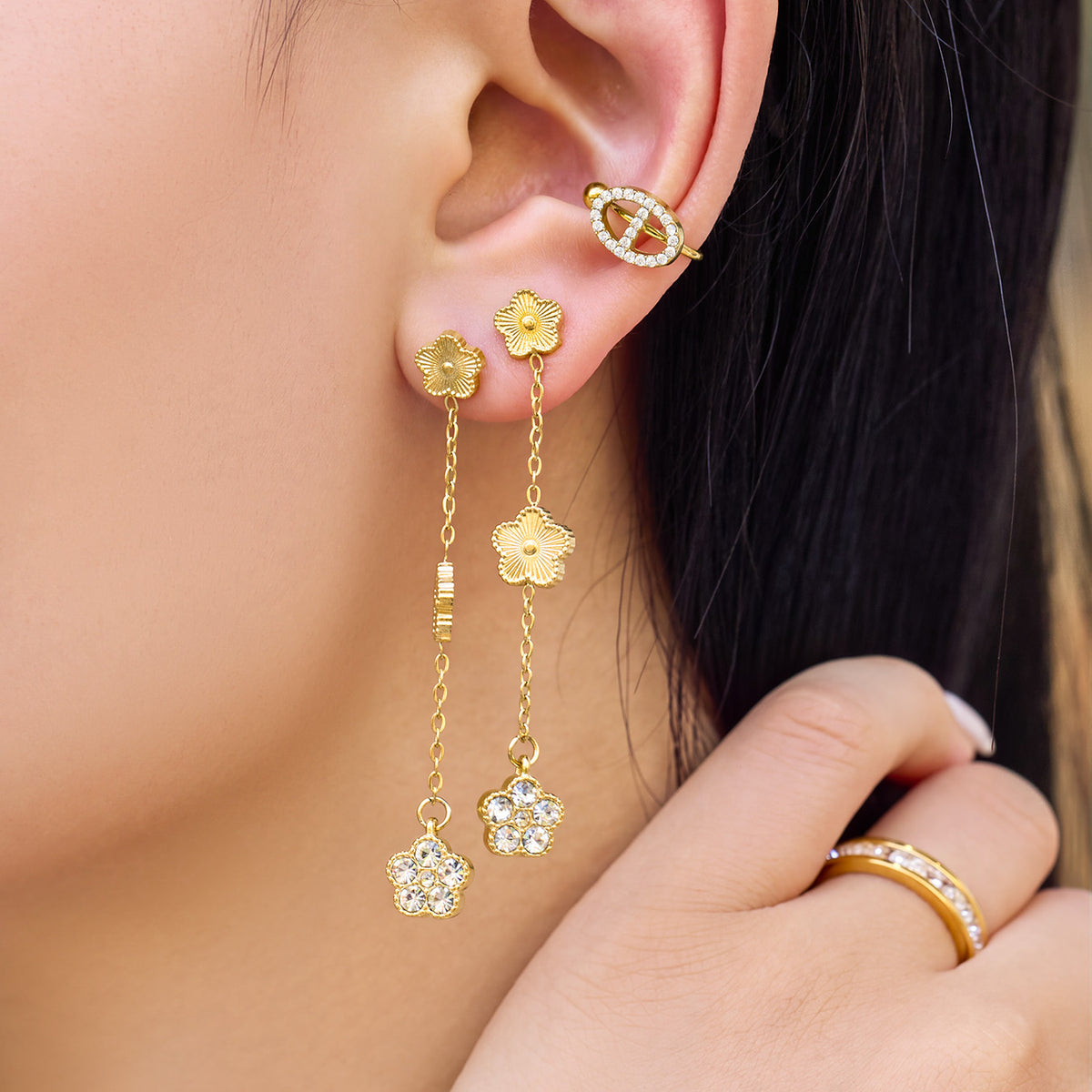 Model wearing zircon flower dangle earrings with a delicate gold chain and multiple floral motifs