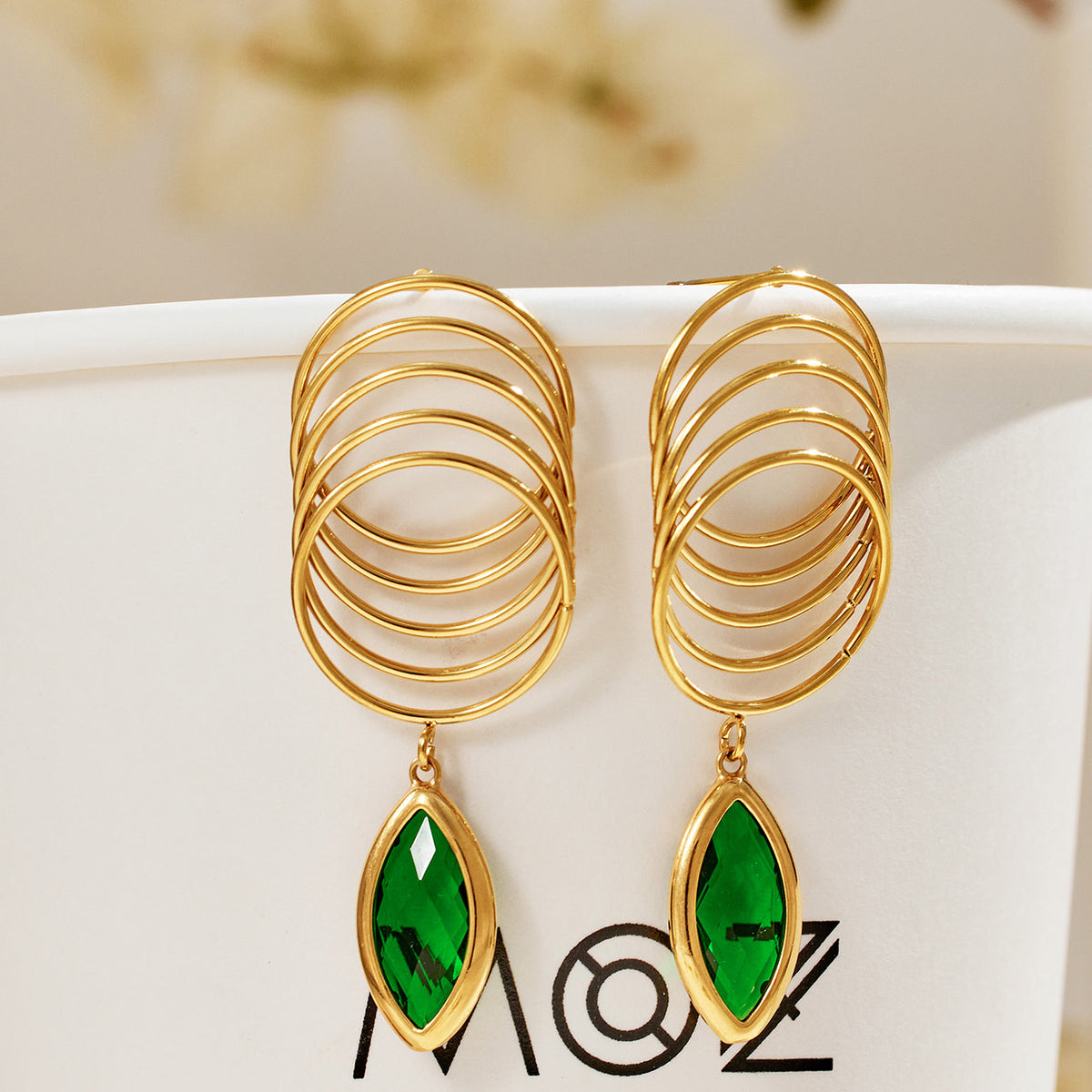 Pair of green glass stone drop earrings with sculptural multi-loop gold-tone stainless steel design