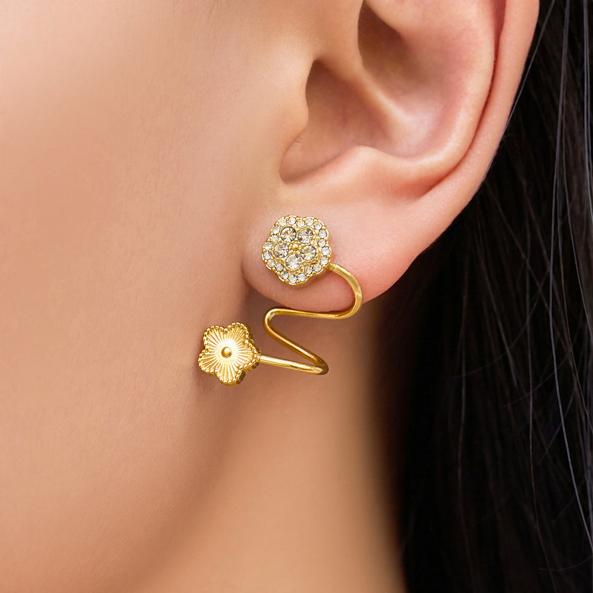 Model wearing a gold flower ear cuff with zircon detail and non-pierced spiral wrap design