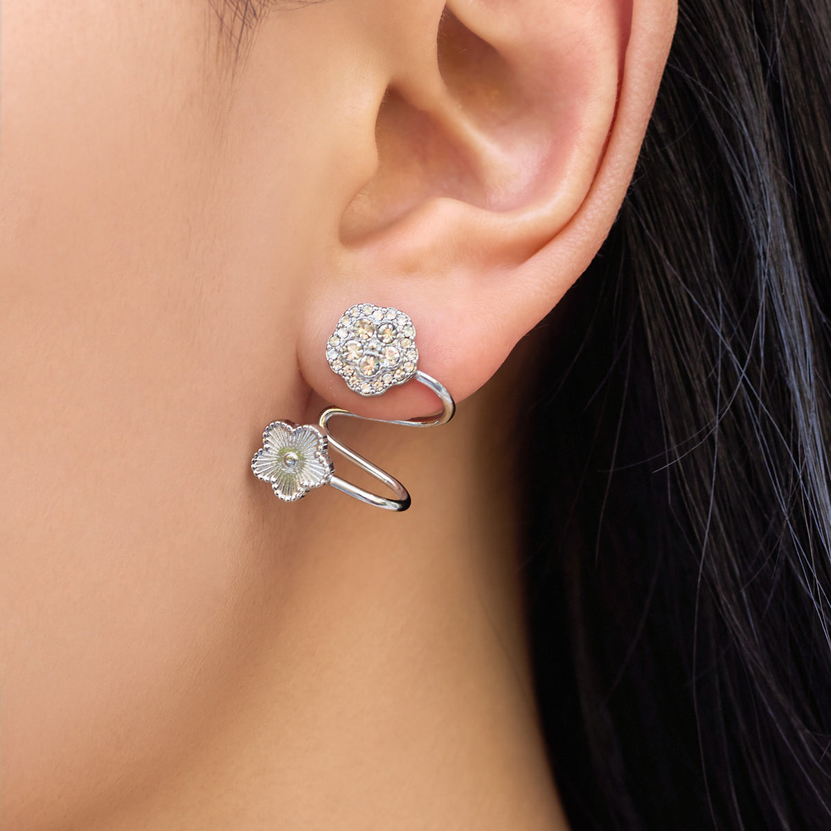 Model wearing silver-tone flower zircon ear cuff with polished stainless steel spiral structure