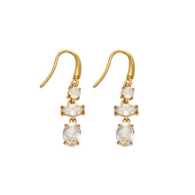 Front view of a pair of gold fishhook drop earrings with three sparkling clear stones arranged vertically