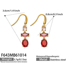 Size reference for gold fishhook drop earrings featuring pink upper accents and red oval dangling stones