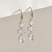 Pair of silver-tone stainless steel drop earrings featuring clear round, marquise-shaped and oval stone accents