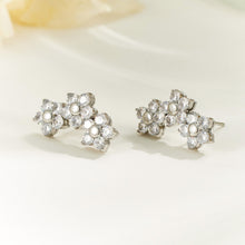 Pair of silver-tone floral cluster earrings displayed on a light background, showing three connected sparkling flowers