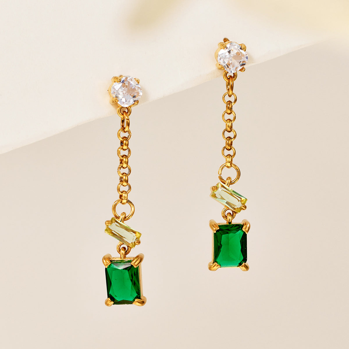 Green baguette zircon drop earrings on a neutral studio background with 18K gold PVD stainless steel finish