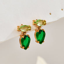 Green teardrop zircon earrings on a neutral studio background with pale green marquise top stones and gold settings