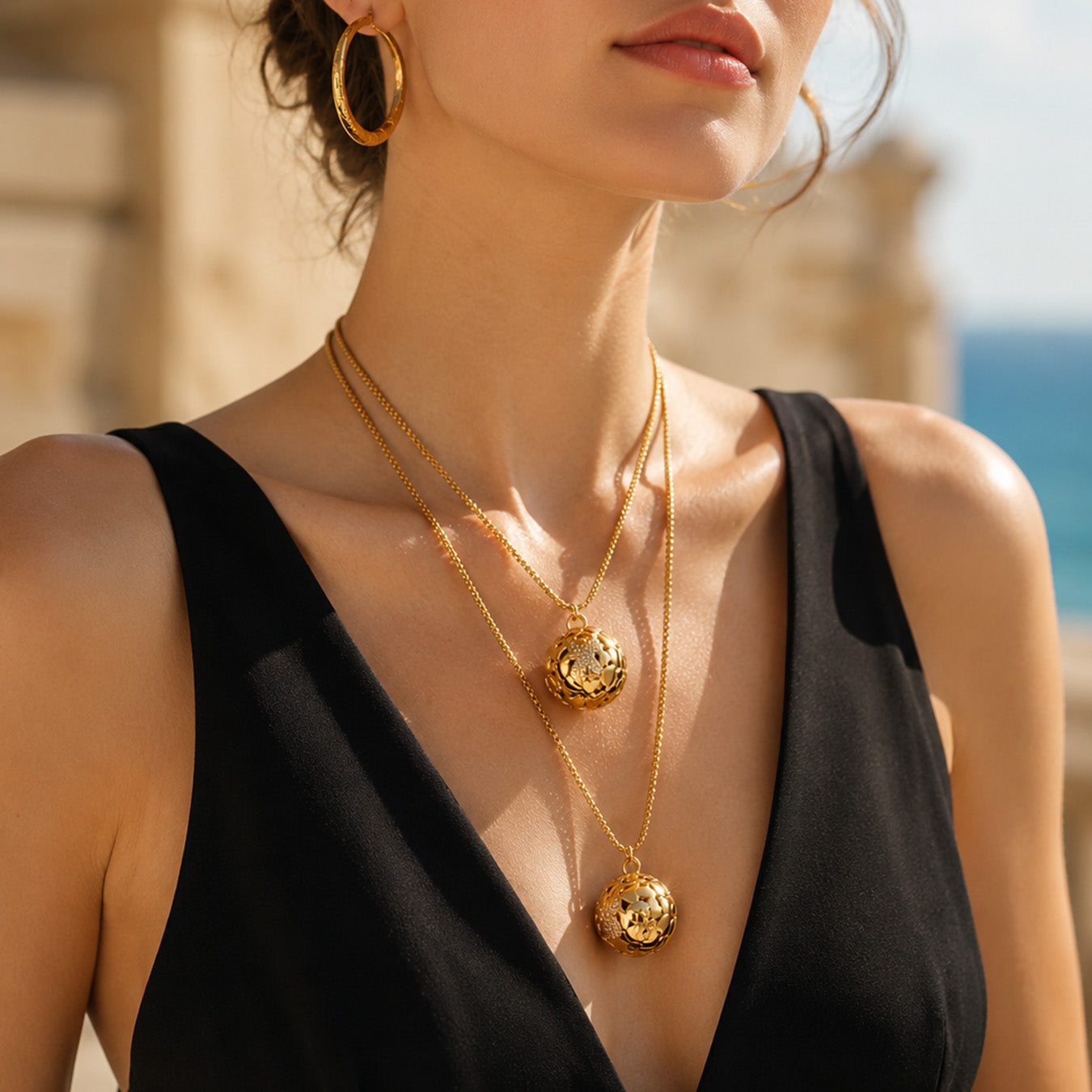 Model wearing a gold textured floral medallion pendant against a neutral background