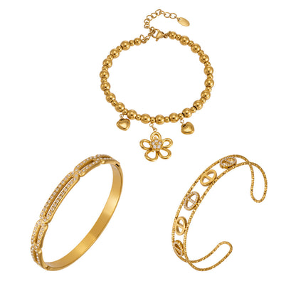 Flower heart zircon bangle collection stacked on wrist with 18K gold and steel tone styles for wholesale boutique buyers