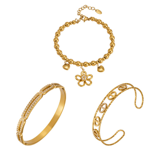 Flower heart zircon bangle collection stacked on wrist with 18K gold and steel tone styles for wholesale boutique buyers