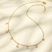 Flower zircon charm necklace flatlay with delicate 18K PVD gold chain and stainless steel finish
