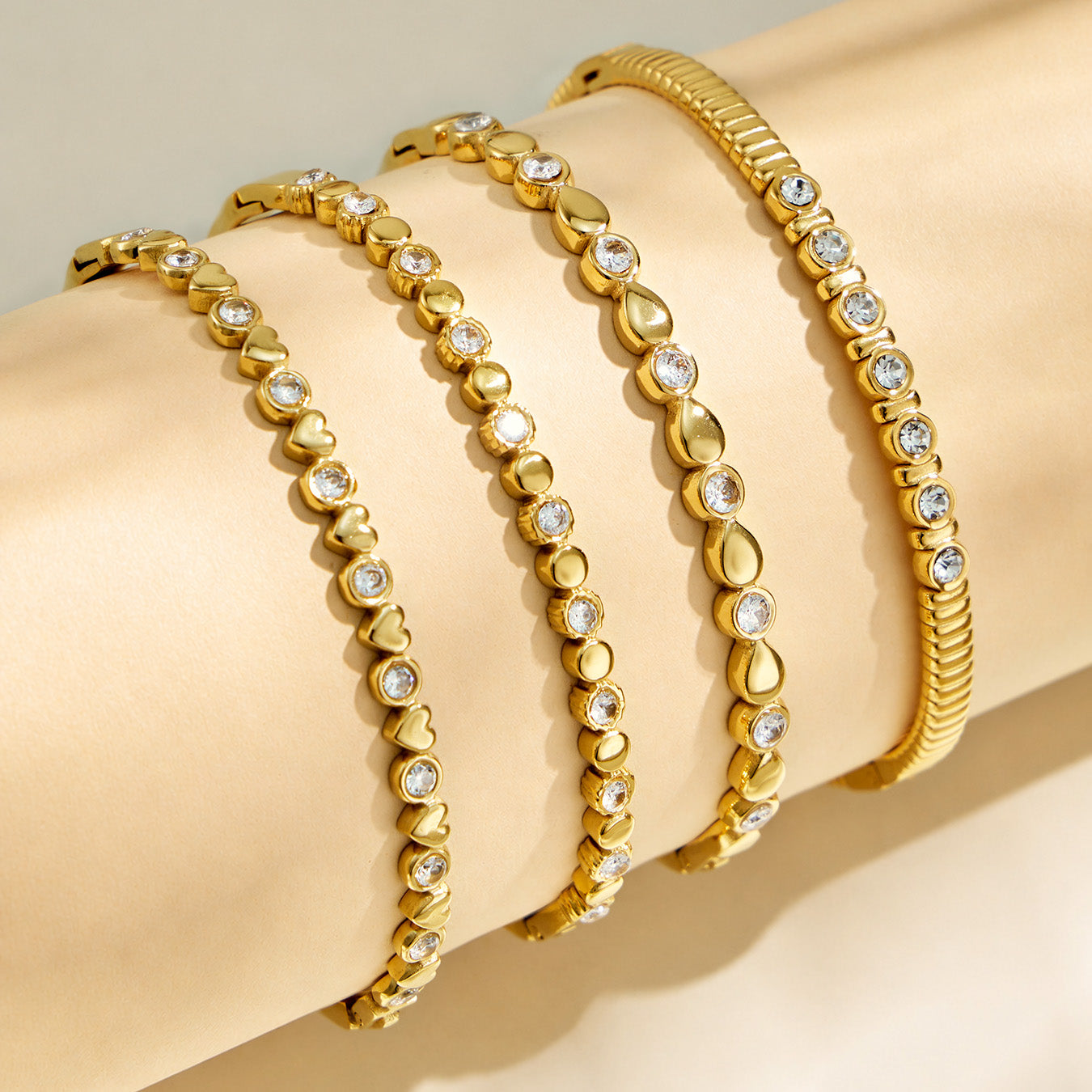 Four gold geometric zircon bangle designs displayed side by side