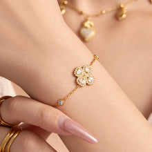 Gold-tone four-petal flower zircon bracelet worn on wrist with sparkling floral centerpiece