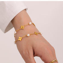 Model wearing a gold freshwater pearl clover bracelet with delicate charm details