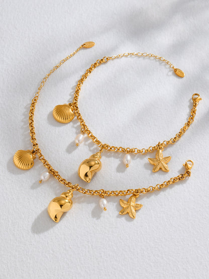Flat lay of matching freshwater pearl shell charm anklet and bracelet set in 18K PVD gold 316L stainless steel