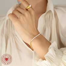 Lifestyle image of a freshwater pearl stainless steel bracelet styled on a model wrist