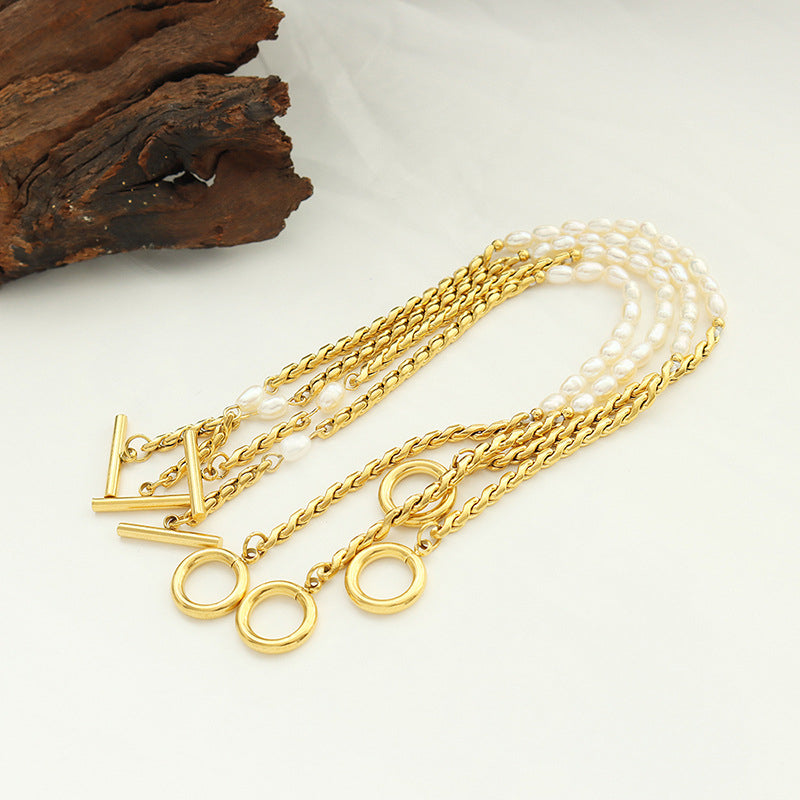 Freshwater pearl toggle clasp bracelet with gold tone stainless steel chain in a boutique flat lay