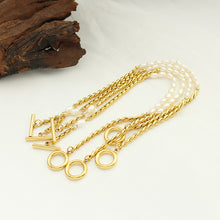 Freshwater pearl toggle clasp bracelet with gold tone stainless steel chain in a boutique flat lay