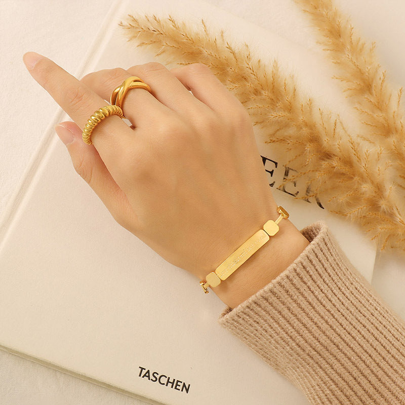 Close-up of geometric bar bracelet with square bead chain details