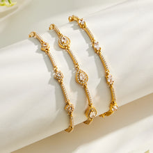 Three gold zircon bracelet styles with heart, square and teardrop motifs displayed together