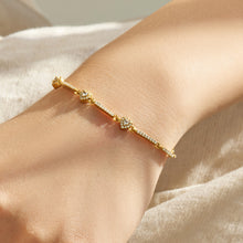 Gold geometric zircon bracelet with sparkling center detail shown in a close-up wrist view