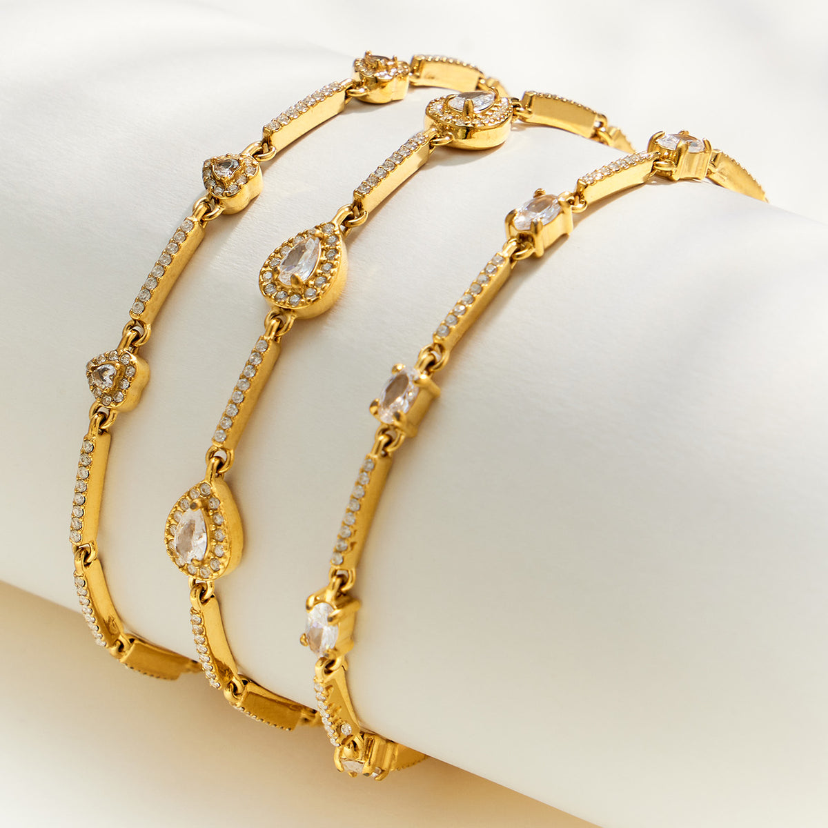 Geometric zircon bracelet assortment showing three delicate gold design variations