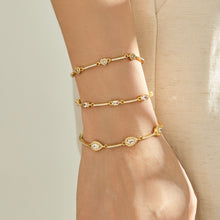Three geometric zircon bracelet designs layered vertically on a model wrist