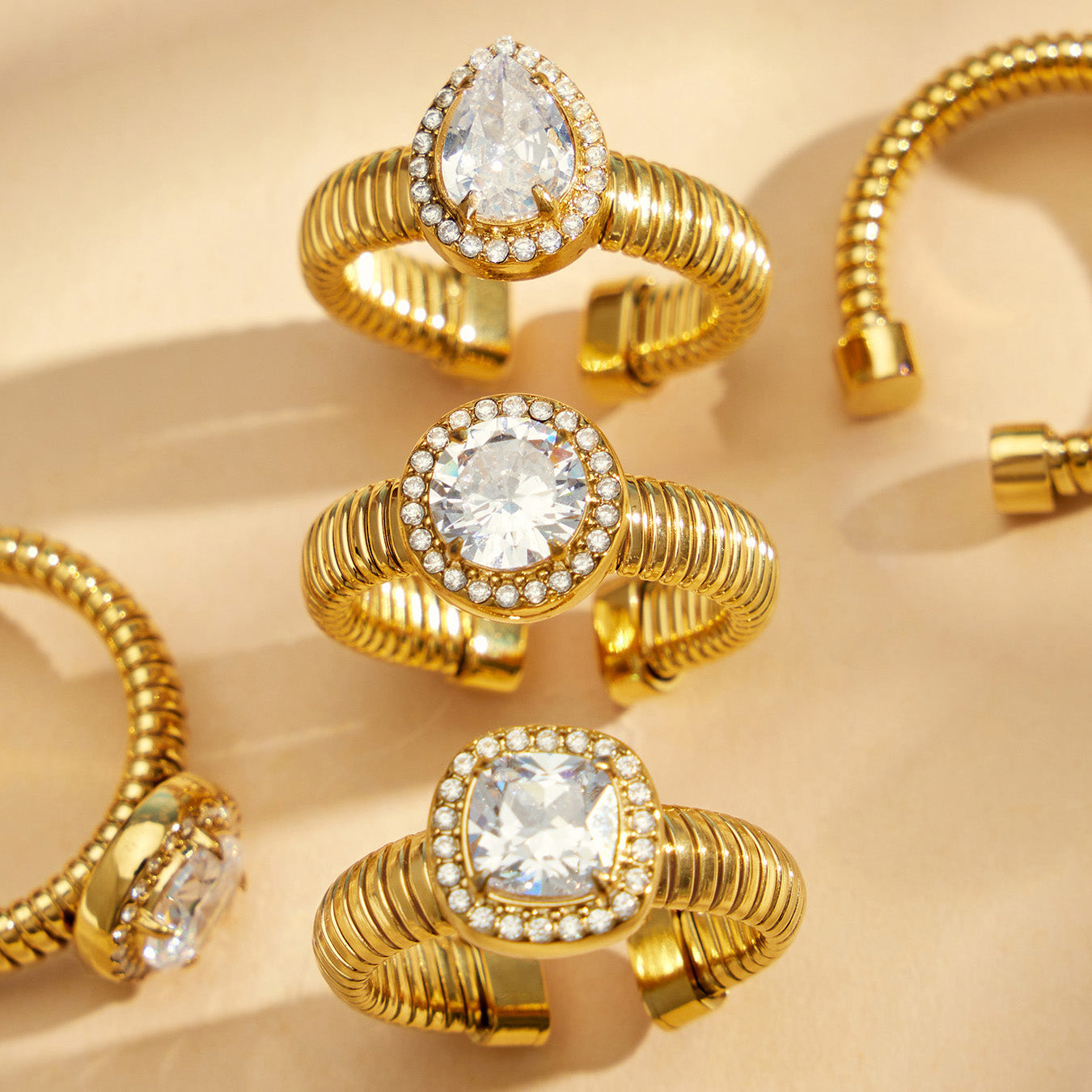 Gold 5A zircon geometric open rings displayed on shell with waterdrop, round and square adjustable ring styles