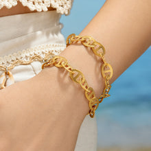Gold anchor link bracelet worn on wrist