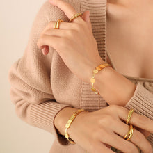 Model wearing a gold bar chain bracelet with geometric metal details