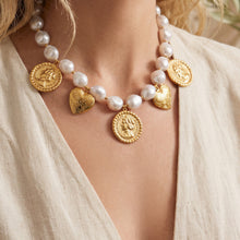 Gold beaded heart charm necklace with ivory beads worn on model