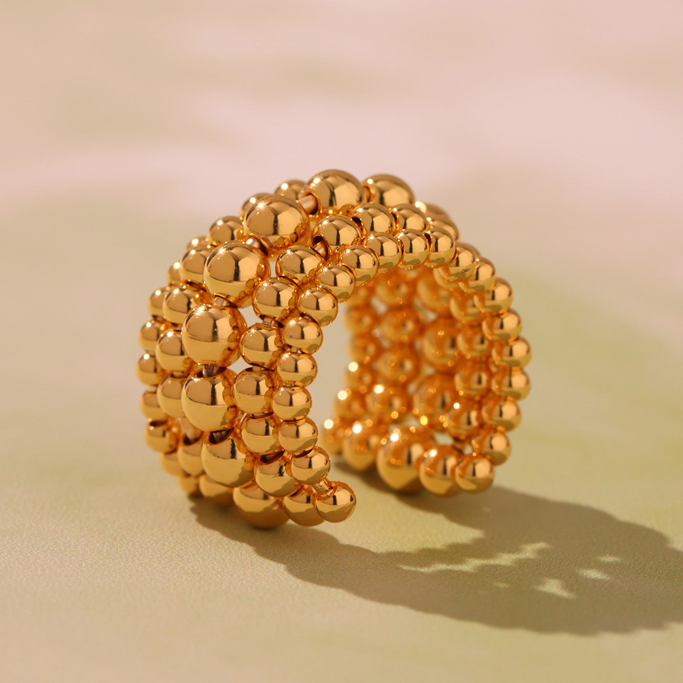 Profile view of gold tone multi-row beaded stainless steel open ring