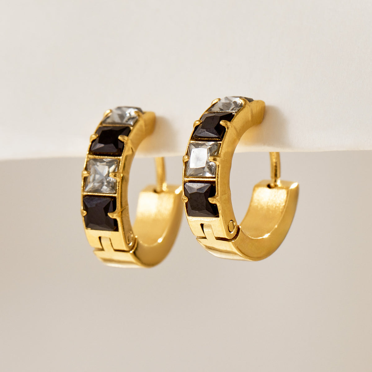 Gold-tone stainless steel huggie hoop earrings with black cubic zirconia