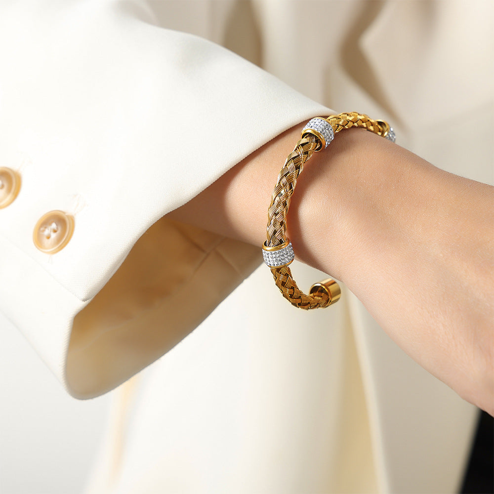 Model wearing an 18K PVD gold braided stainless steel open bangle on the wrist
