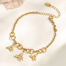 Gold butterfly charm bracelet with adjustable extender arranged in a circular flat lay