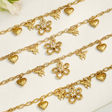 Close-up arrangement of gold butterfly flower and heart charm chains with zircon details