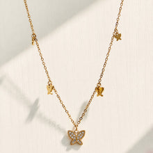 Gold butterfly zircon pendant necklace displayed on a neutral fabric background