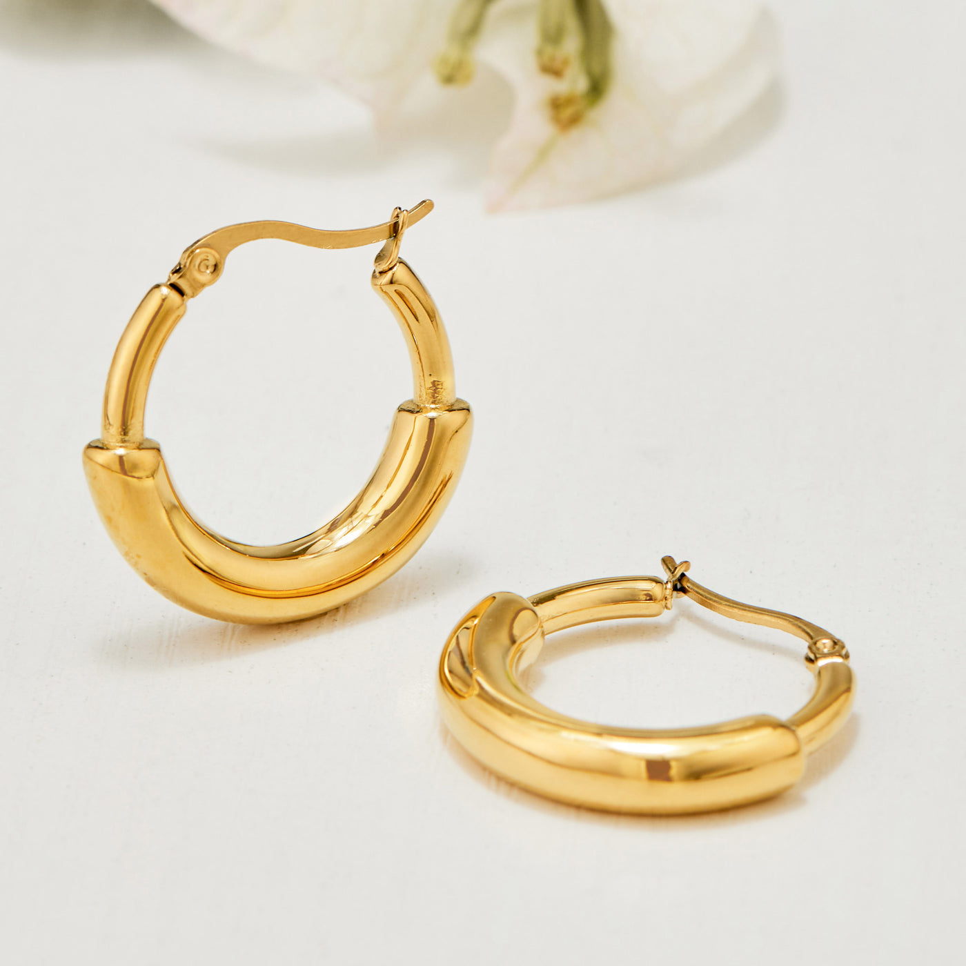 Single gold C-shaped hoop earring with a smooth polished wide profile