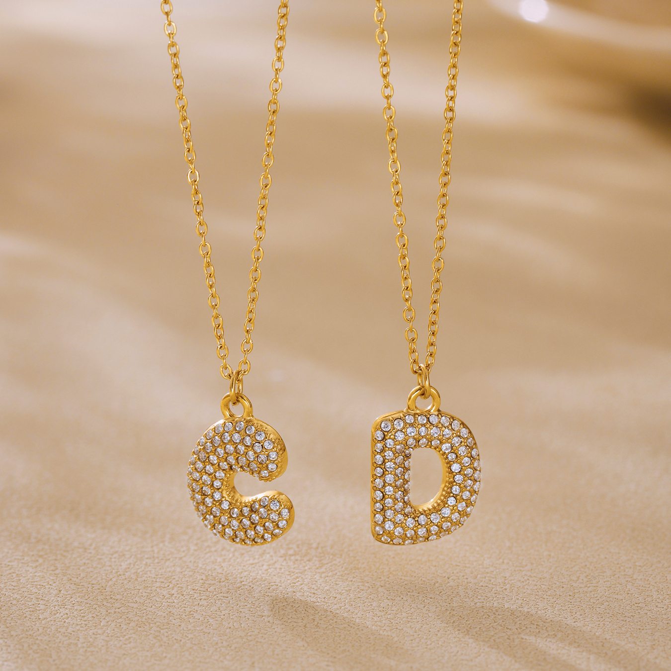Gold C and D iced out initial letter necklaces with zircon pave pendants for personalized boutique jewelry