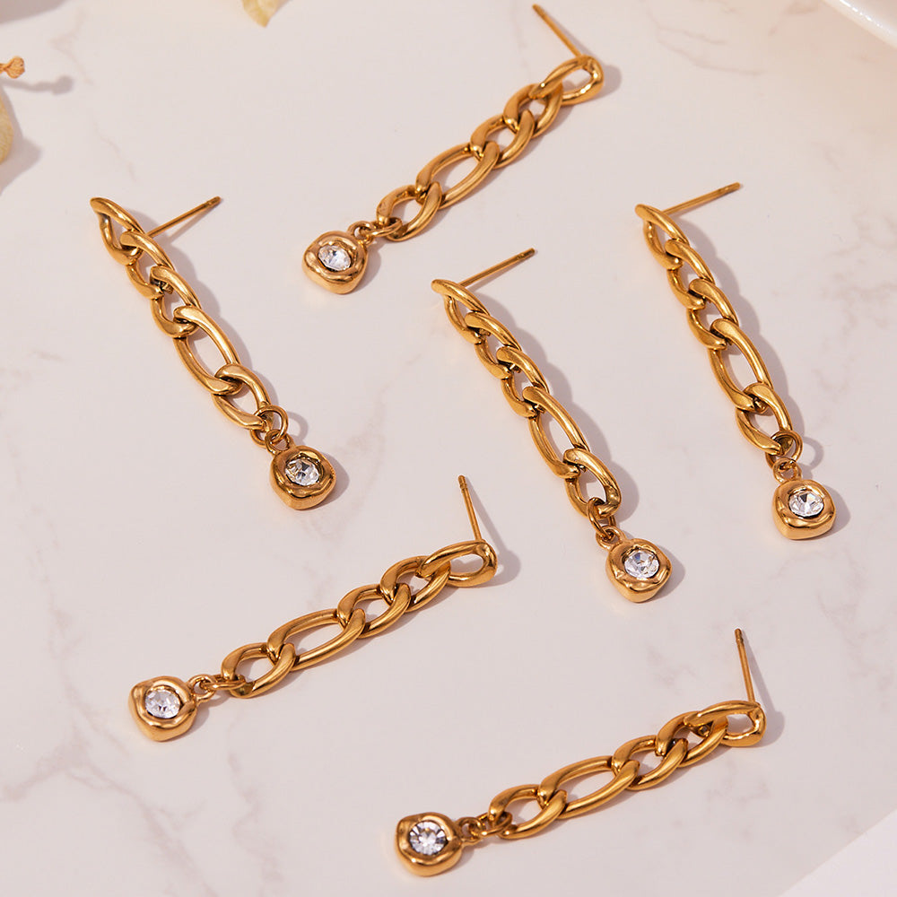 Multiple views of gold link chain drop earrings arranged in a clean product flat lay