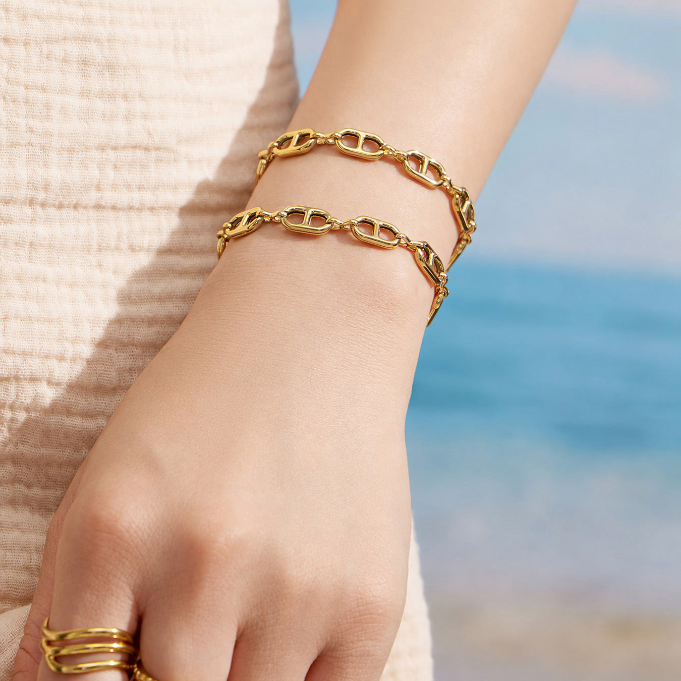 Gold chain link bracelet worn outdoors with an adjustable extender chain
