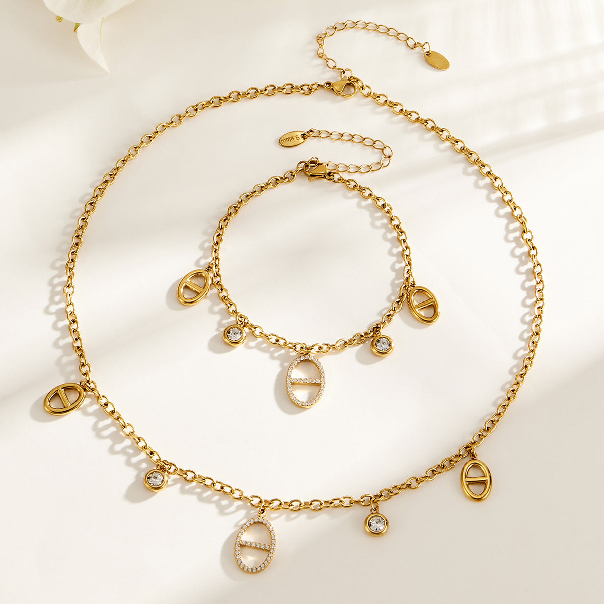 Gold stainless steel zircon charm bracelet and necklace flat lay