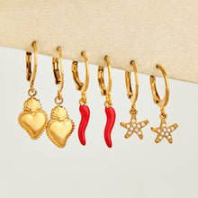 Mixed gold charm huggie earrings with heart, chili pepper and starfish designs arranged in a row