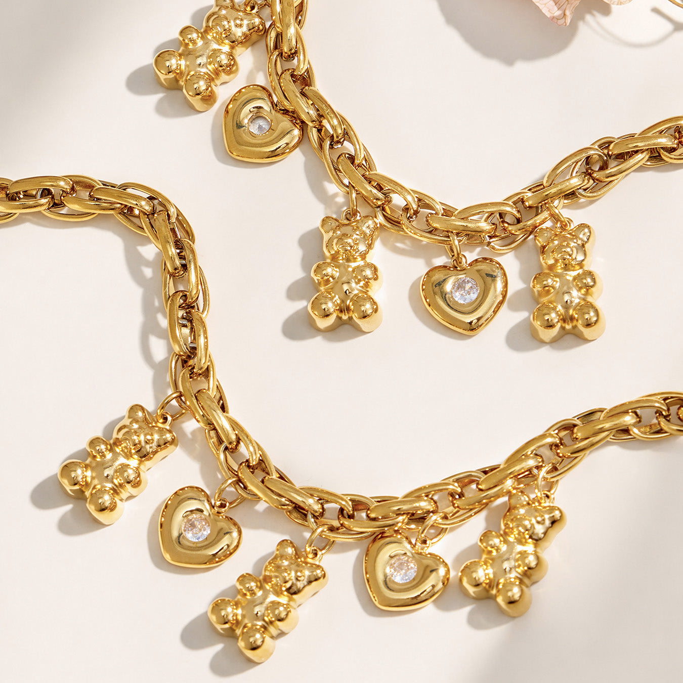 Layered gold chunky charm necklaces with teddy bear and heart details