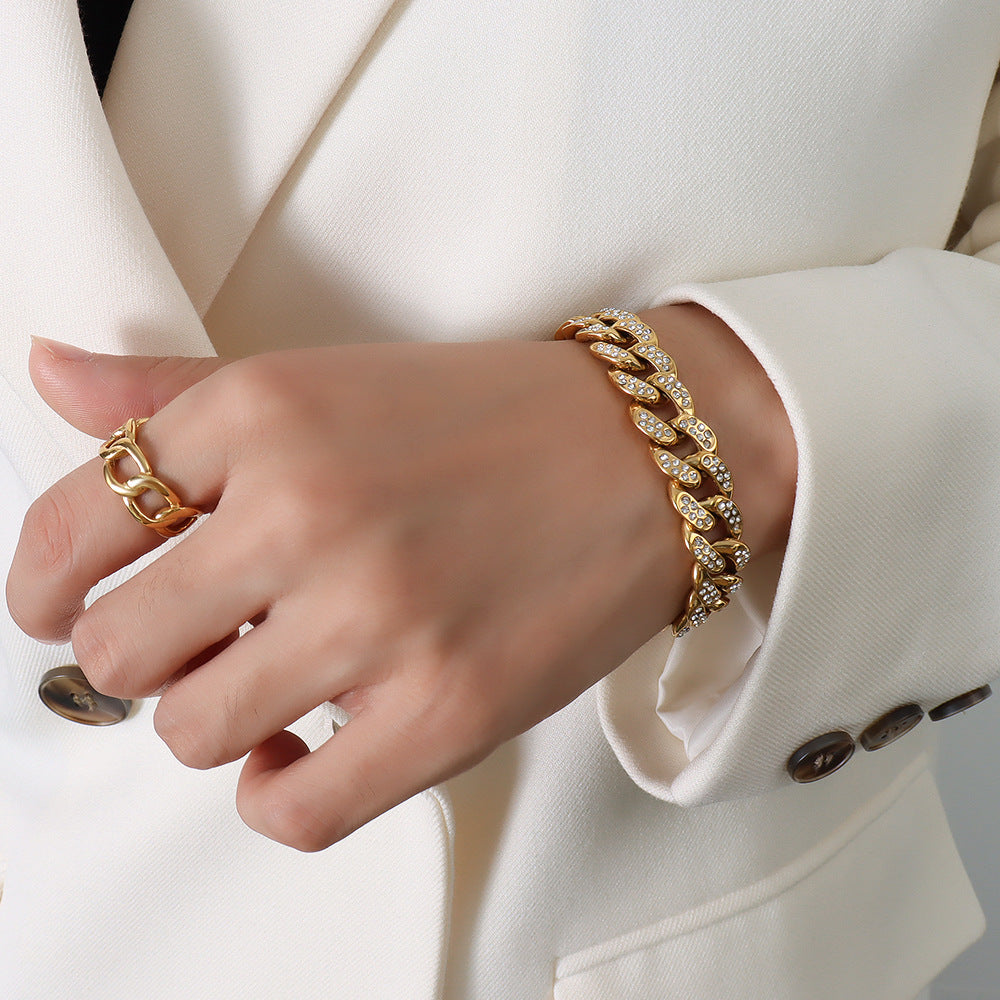 Gold chunky Cuban link bracelet with clear cubic zirconia styled with a neutral outfit