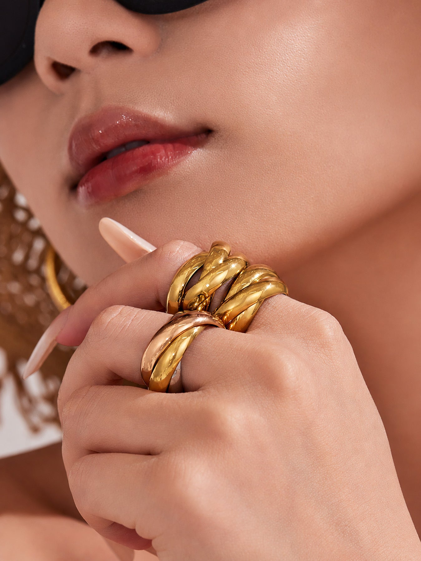 Gold chunky double ring worn on hand with sculptural interlocking band for statement jewelry collections